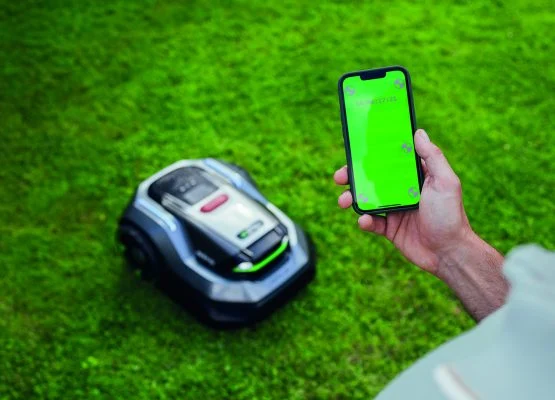vue de l'application en premier plan, le robot RMR est en second plan sur une pelouse