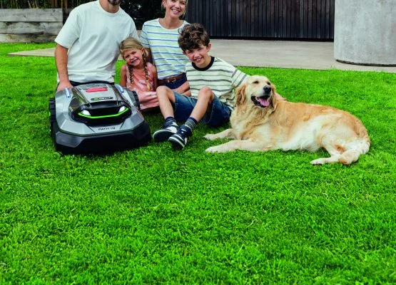 photo d'une famille sur une pelouse avec 2 adultes, 2 enfants, un chien et le robot RMR